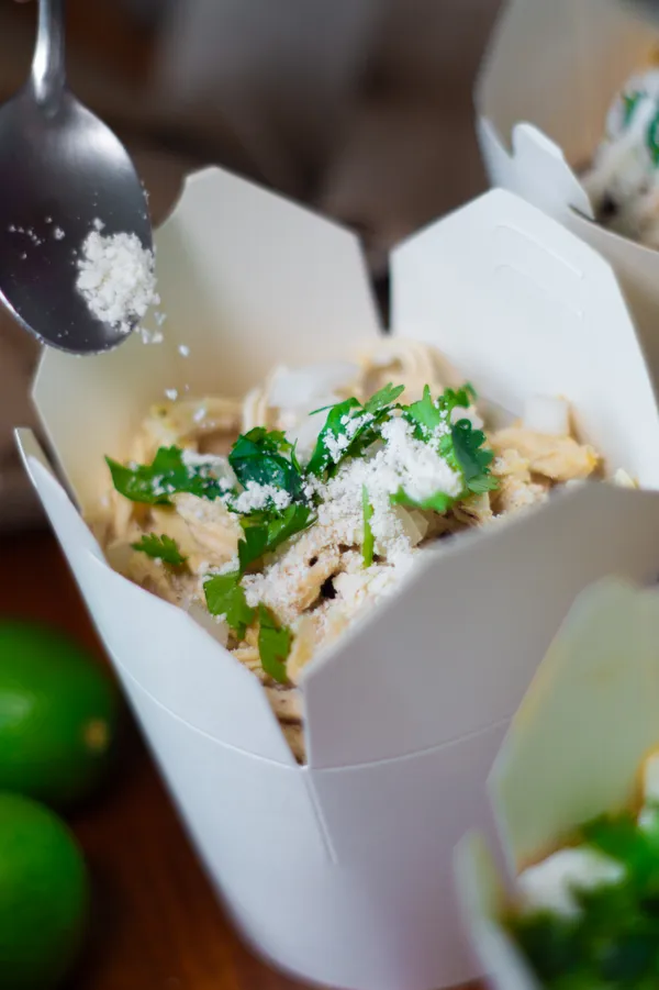 Garnishing chilaquiles with cheese